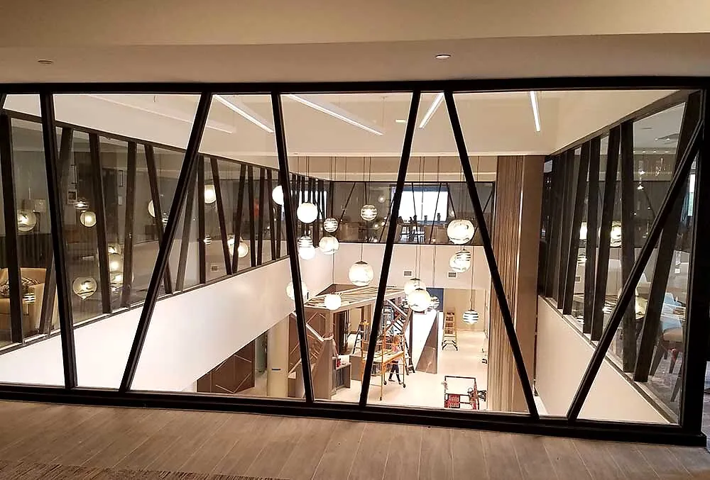 Modern commercial atrium with black steel trusses and lighting
