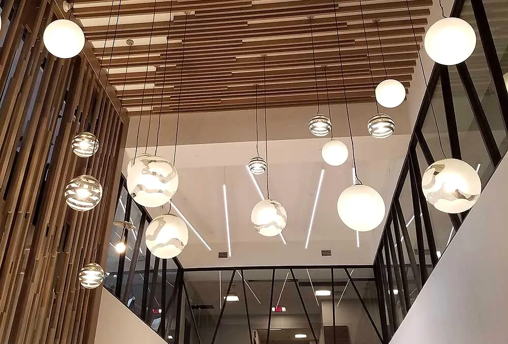 Architectural LED pendant lighting under a wood-slat commercial ceiling
